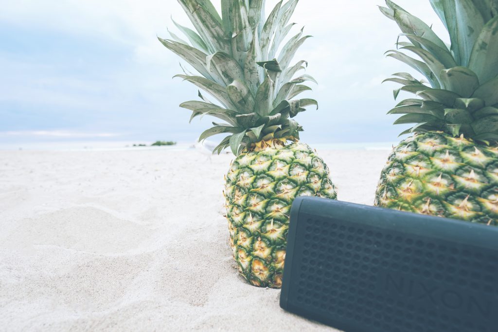 Pineapples on the beach with music playing for a Tropical Christmas Party