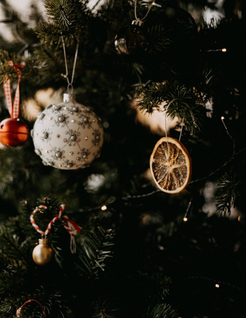 Pineapple and Dried Citrus ornaments hanging from a Christmas tree.