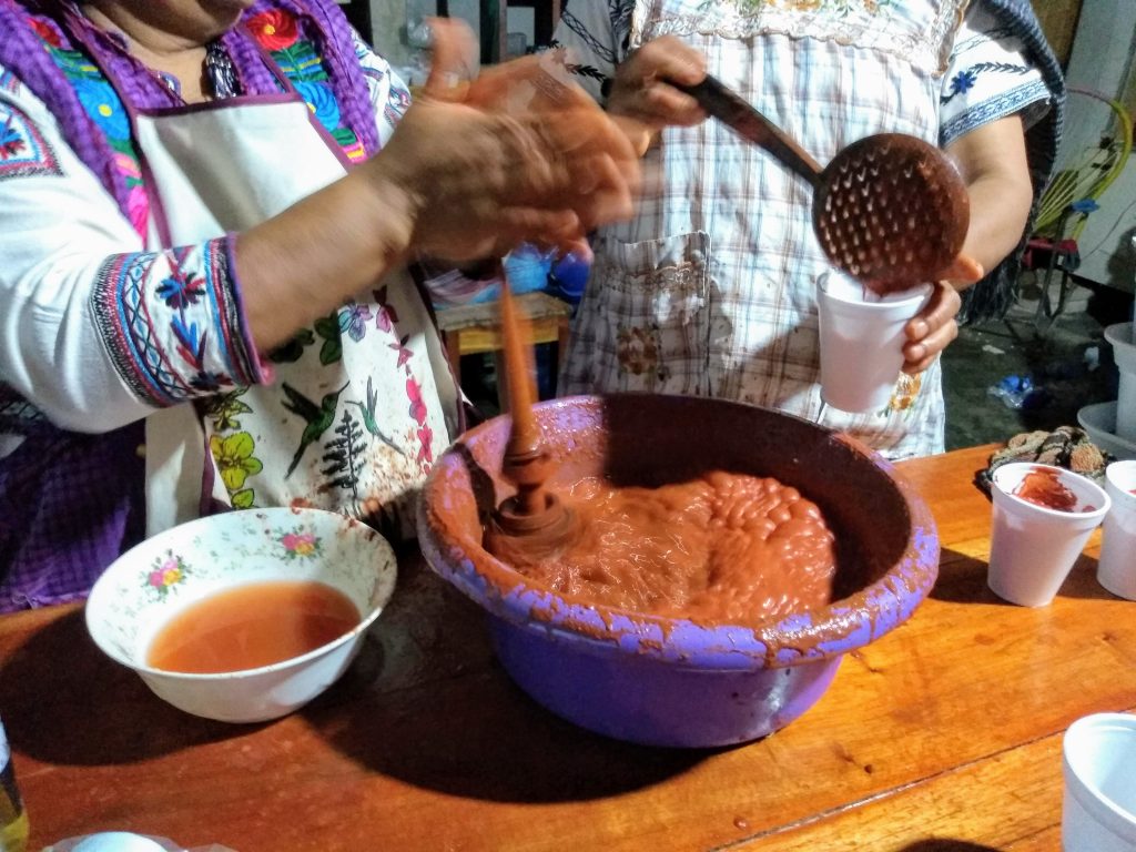 Two women mix traditional tepache, one of many pineapple flavored foods.