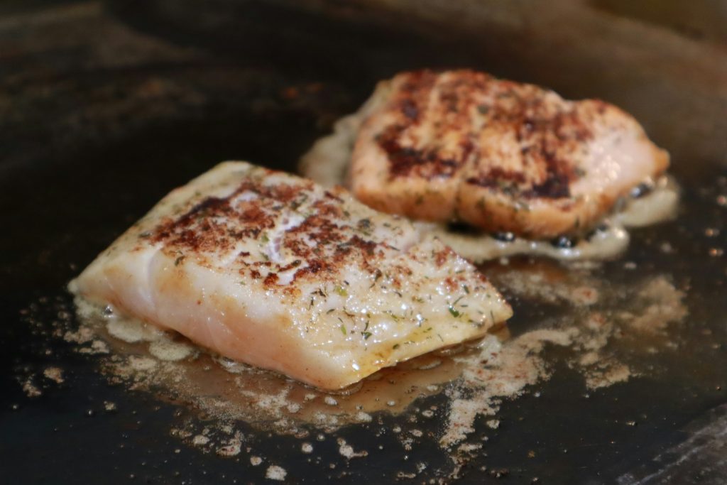 mahi filets sizzling on a flattop